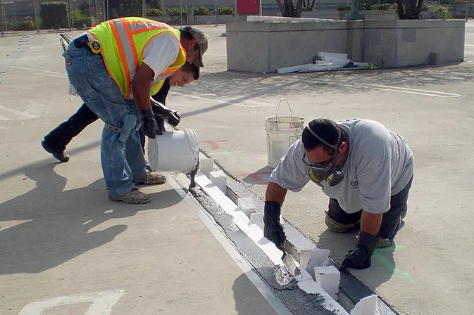 Sealant installed at expansion joint margins by Angelus Waterproofing employees at Montclair Plaza, Montclair, CA